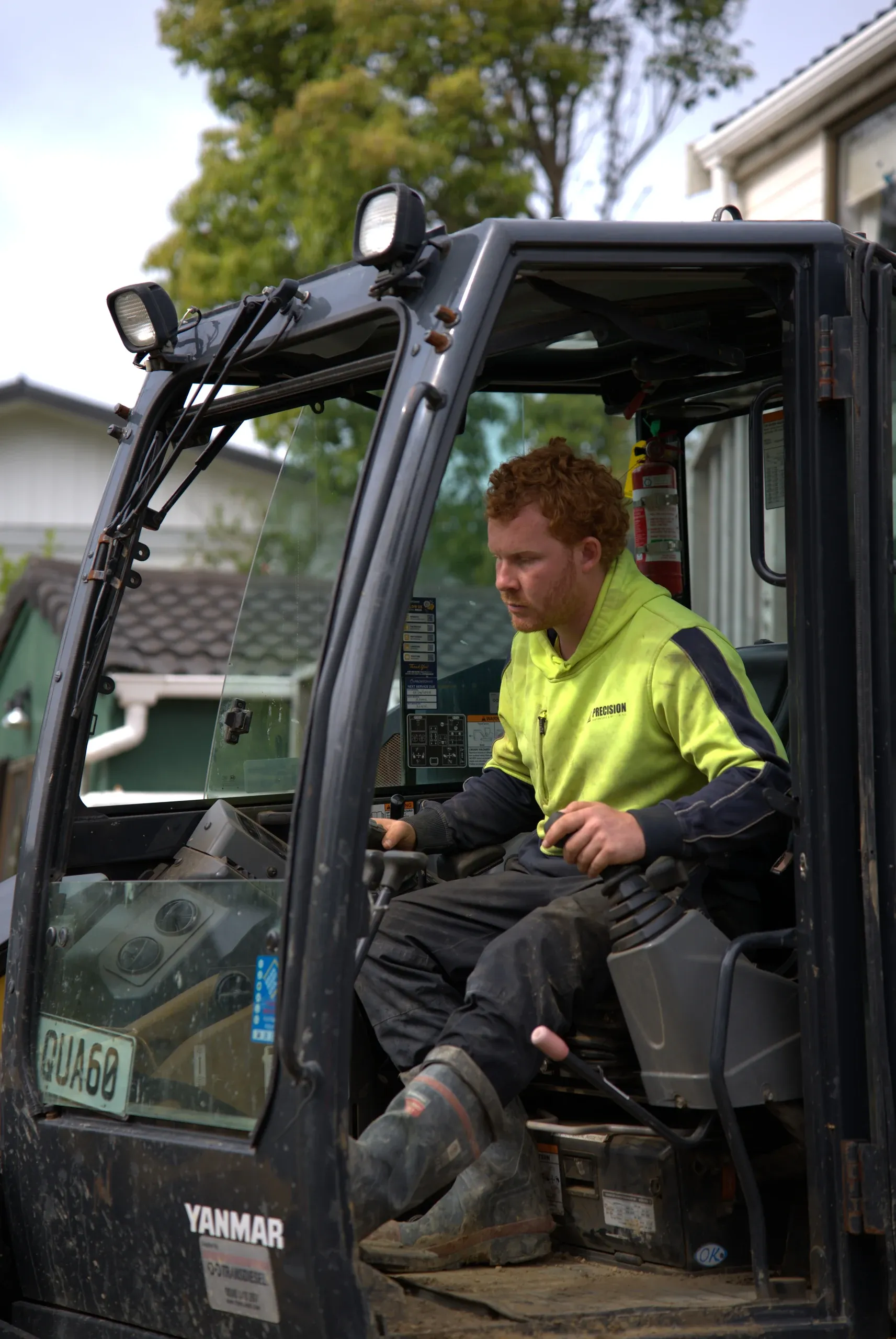 Operator working the excavator from the cab during the Lynfield retaining works.