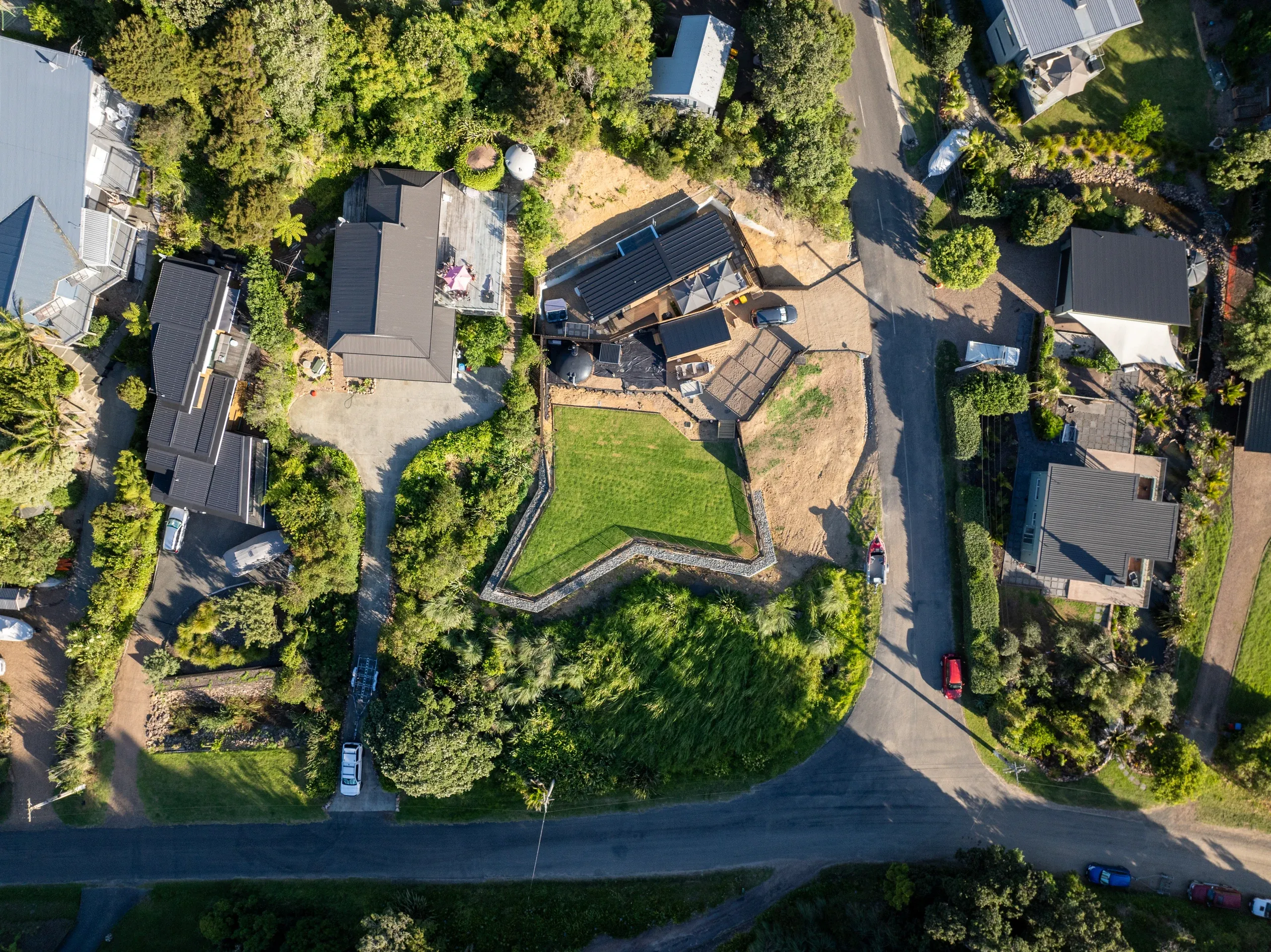 Close aerial over the finished lawn, with the gabion wall and fencing defining the new boundary.