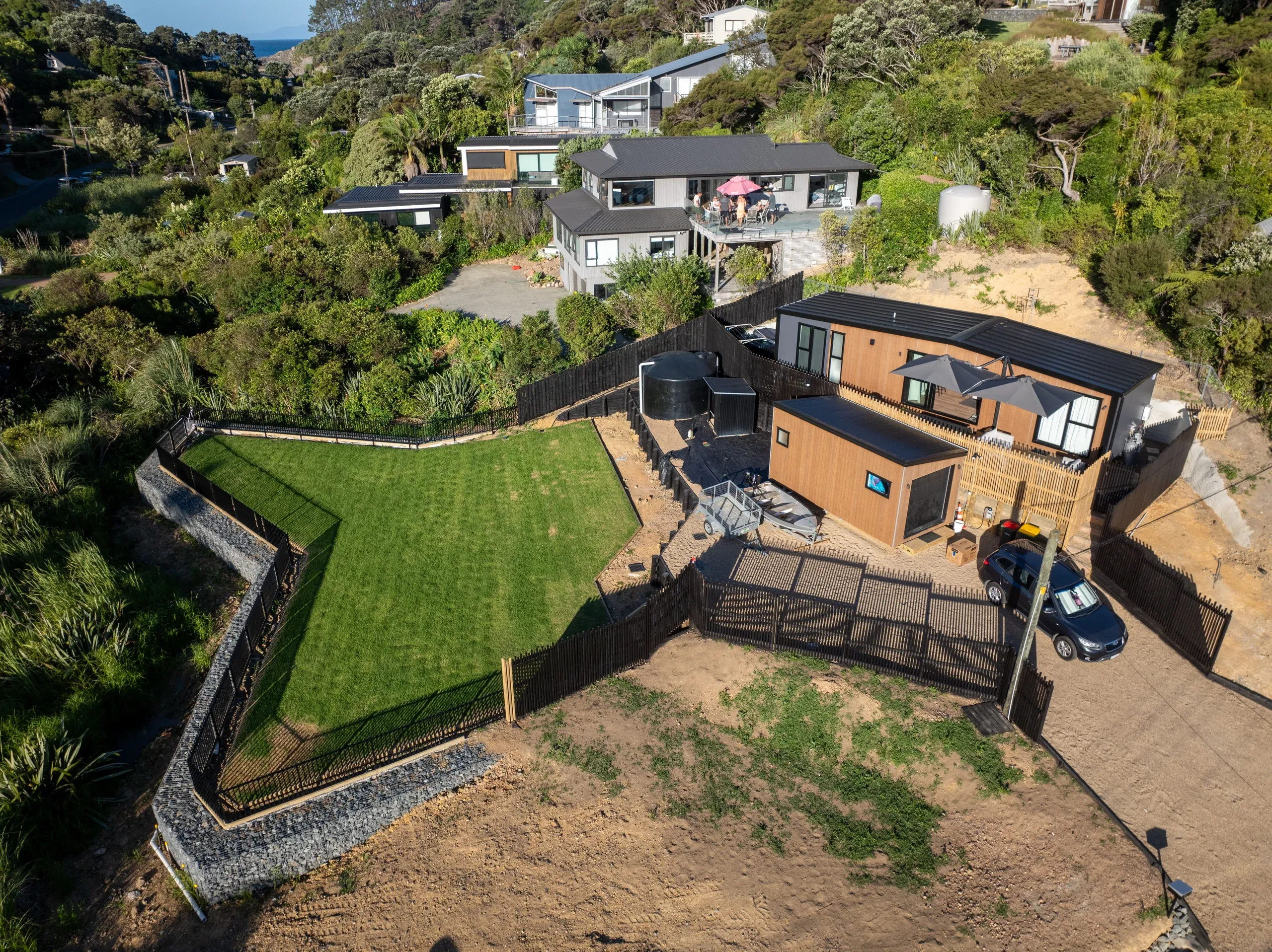 Aerial view of the finished lawn and driveway, gabion retaining holding the level across the slope.