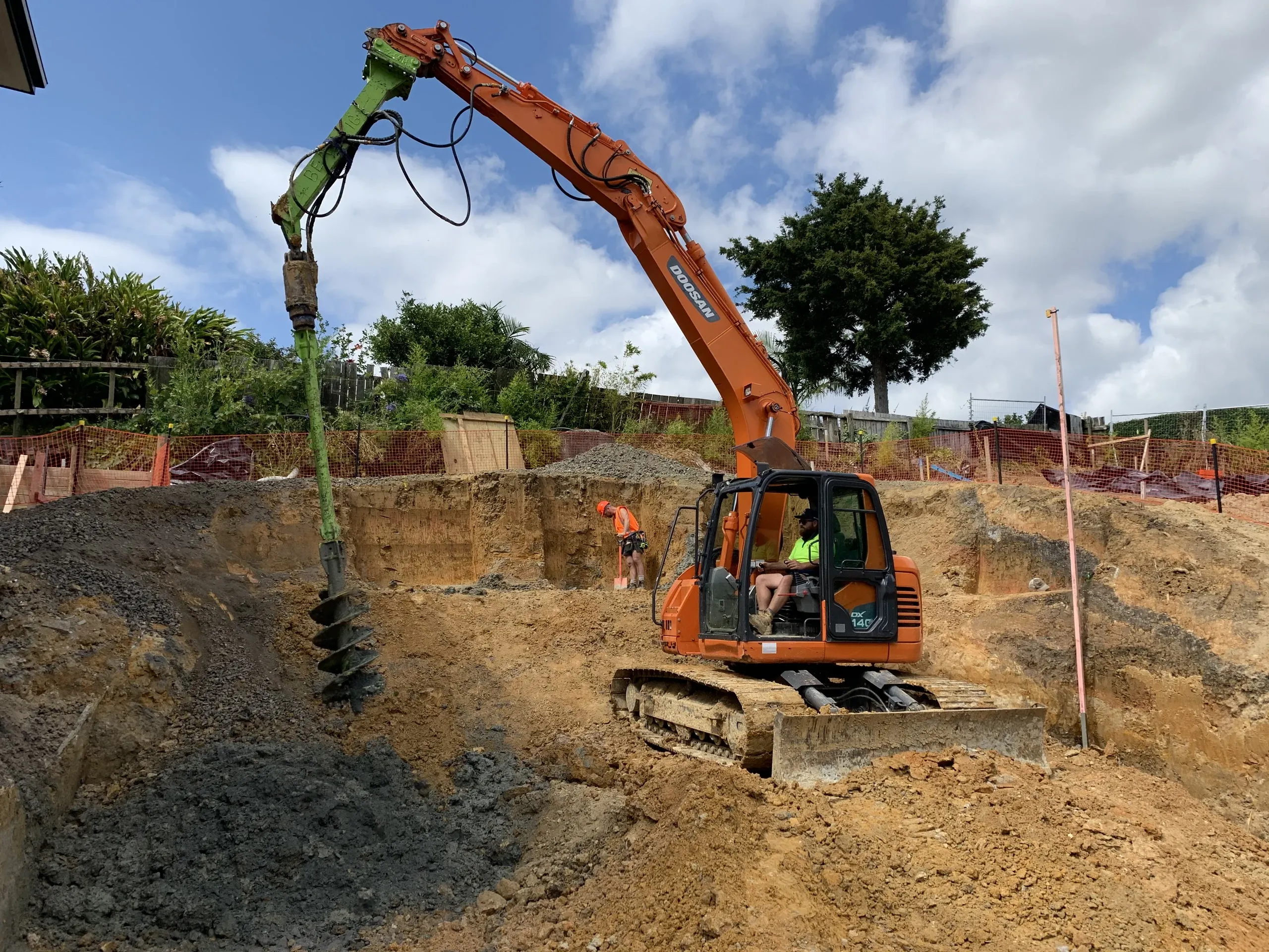 Steel pile being lowered into a bored hole during a piling install